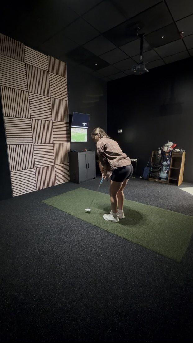 Golfer practicing in the private simulator bay at Impact Performance